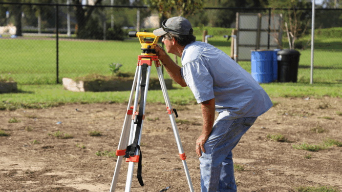 Profissional realizando o levantamento topográfico do terreno